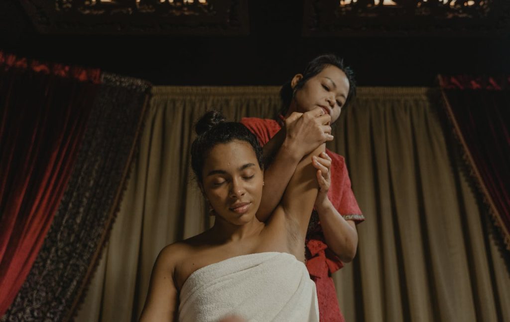 A serene indoor massage scene with two women focusing on relaxation and therapy.