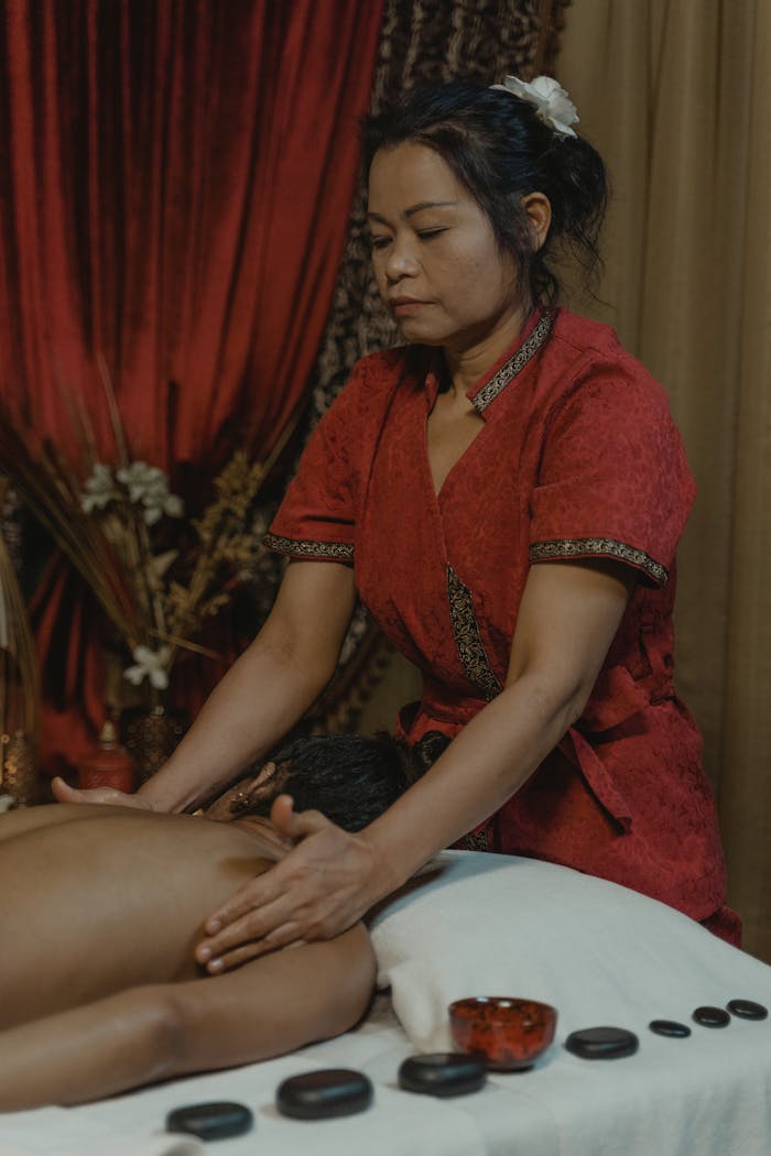 A woman performing a relaxing massage therapy session indoors.